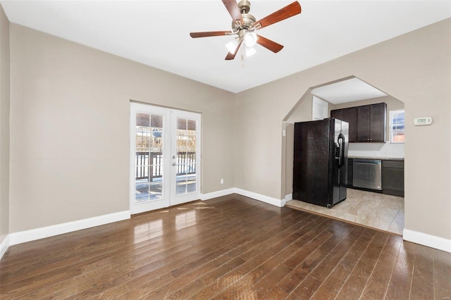 unfurnished living room featuring french doors, plenty of natural light, and wood finished floors