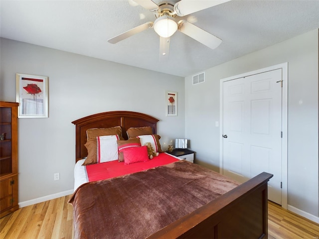 bedroom with ceiling fan, a closet, and light hardwood / wood-style flooring