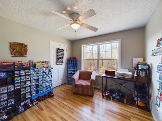 office featuring a textured ceiling, hardwood / wood-style flooring, and ceiling fan