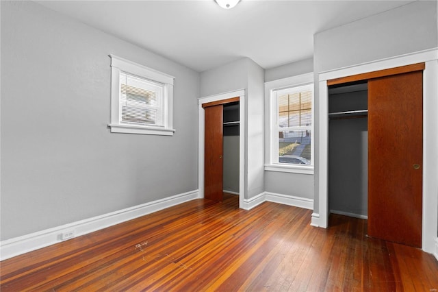 unfurnished bedroom featuring dark hardwood / wood-style flooring and multiple windows