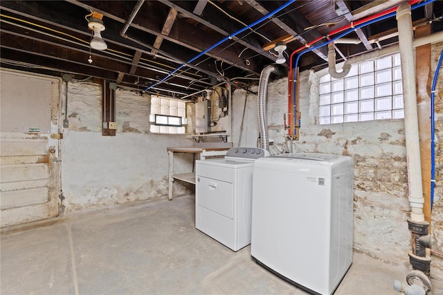 basement with washing machine and dryer, electric panel, and fridge