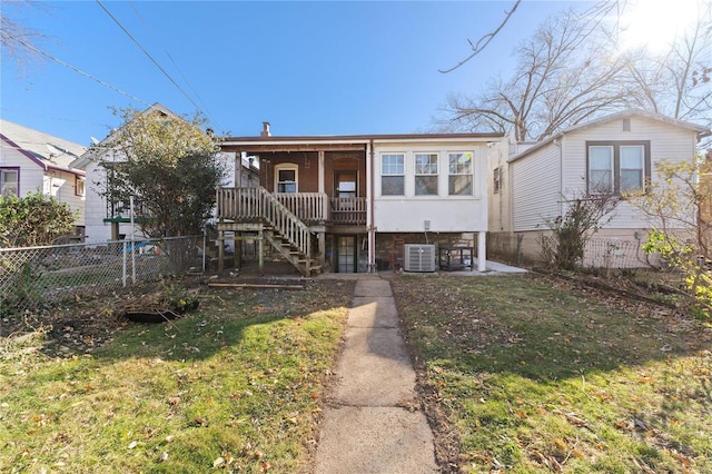 view of front of home featuring cooling unit and a front lawn