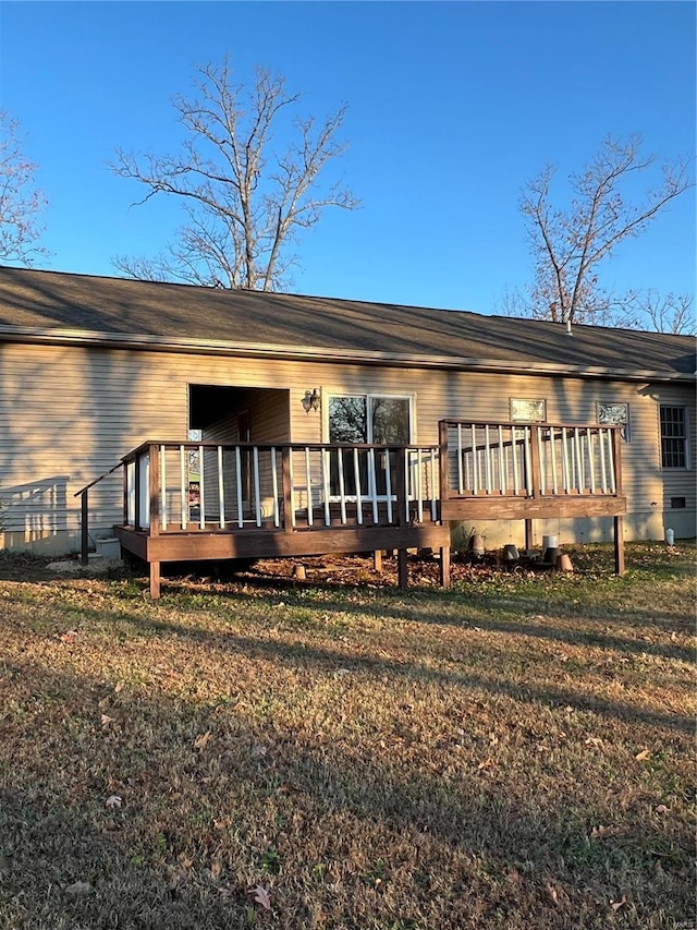 rear view of house featuring a yard and a deck