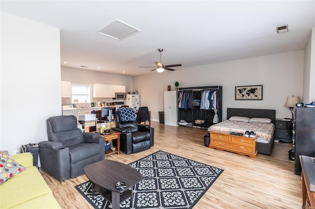 living room with light hardwood / wood-style flooring and ceiling fan