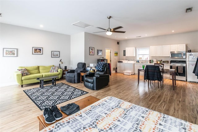 living room with light hardwood / wood-style floors and independent washer and dryer