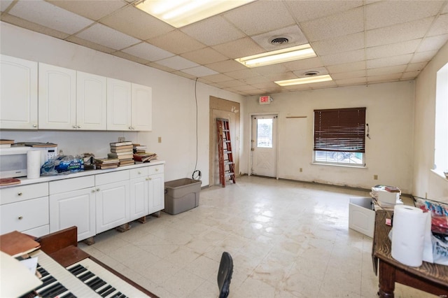 kitchen featuring white cabinets and a drop ceiling