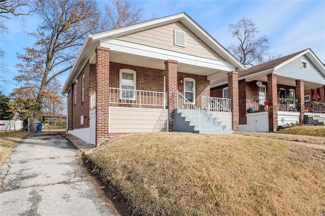 view of front of house with a porch and a front yard