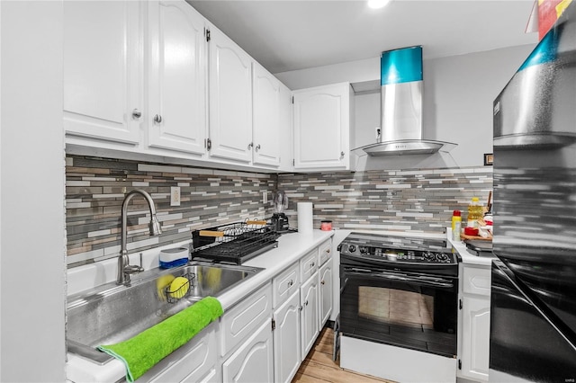 kitchen featuring sink, electric range oven, white cabinetry, and wall chimney range hood