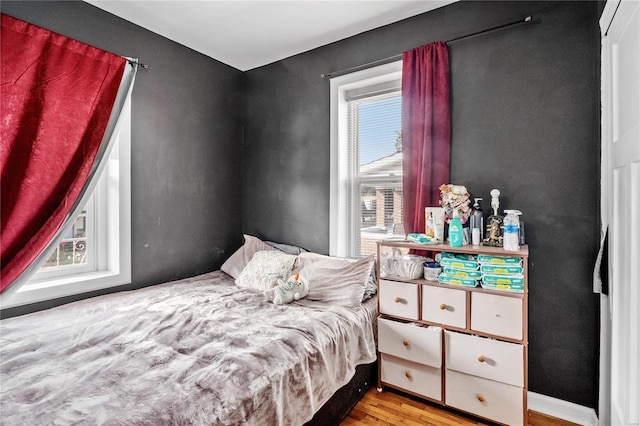 bedroom featuring multiple windows and light wood-type flooring