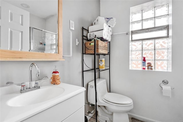 bathroom featuring walk in shower, a wealth of natural light, vanity, and toilet