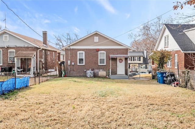 rear view of property featuring a yard