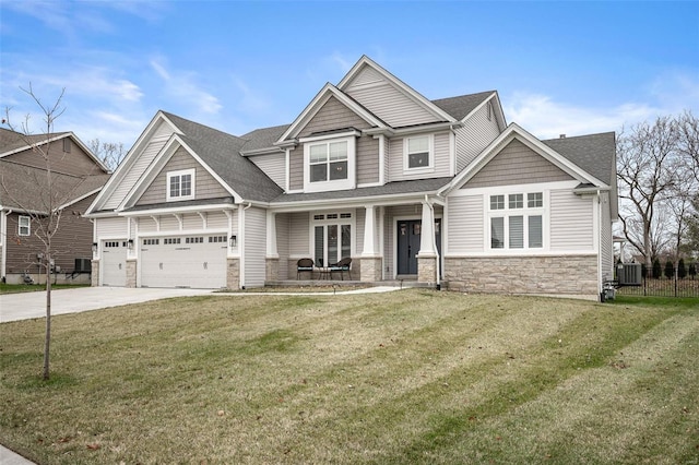 craftsman inspired home with cooling unit, covered porch, a front yard, and a garage