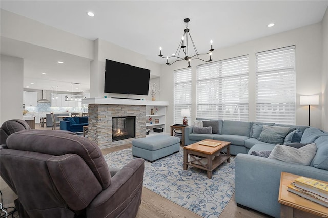 living room with a notable chandelier, light hardwood / wood-style floors, and a fireplace