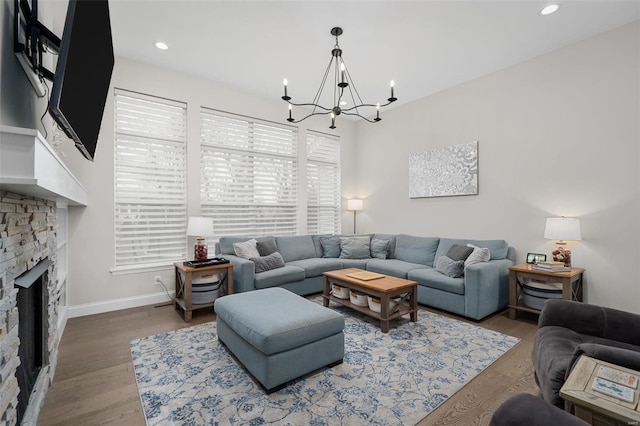 living room featuring a fireplace, hardwood / wood-style flooring, and a chandelier