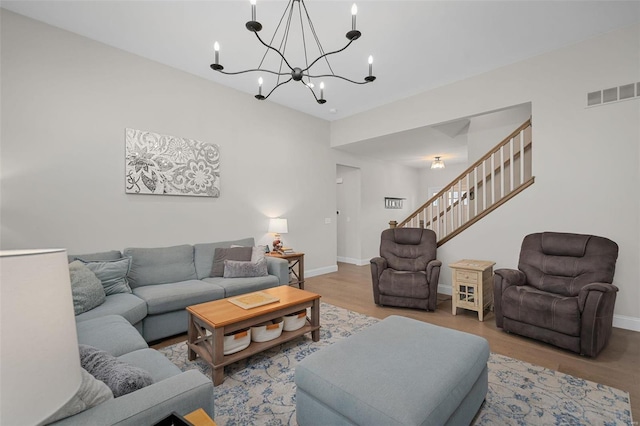 living room with an inviting chandelier and light hardwood / wood-style flooring