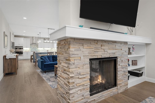 living room featuring hardwood / wood-style floors and a stone fireplace