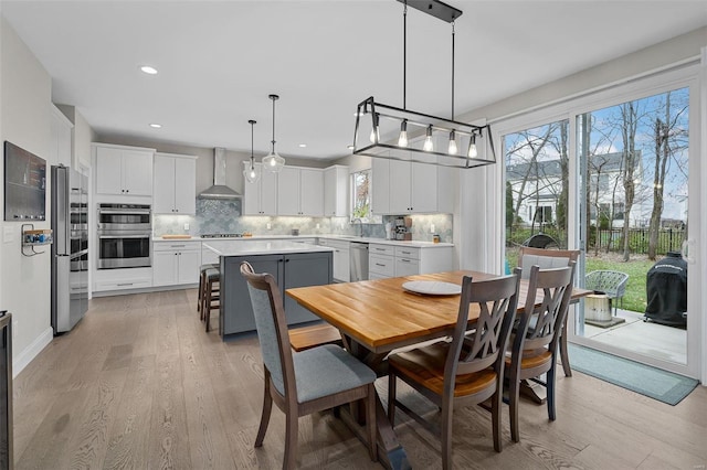 dining space featuring light wood-type flooring and a wealth of natural light