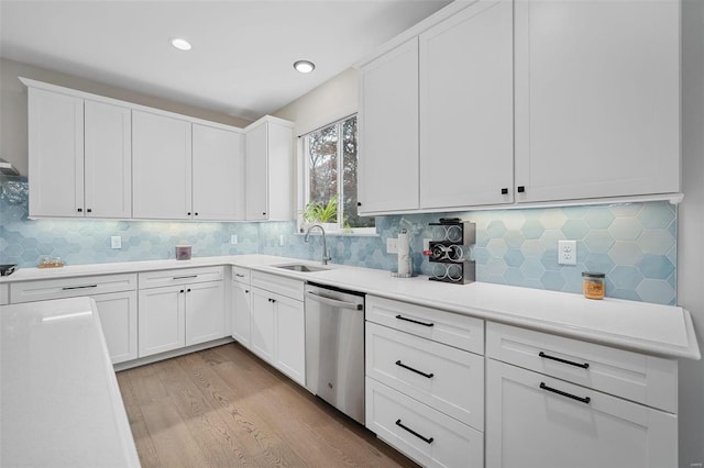 kitchen with white cabinets, light hardwood / wood-style flooring, dishwasher, and sink