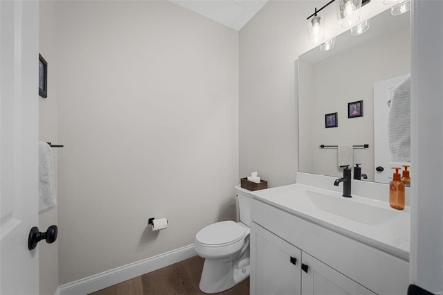 bathroom with hardwood / wood-style flooring, toilet, and vanity