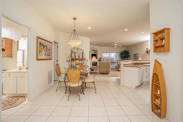 dining space featuring ceiling fan, light tile patterned floors, and sink