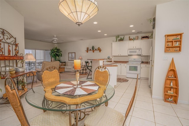 dining space with light tile patterned floors, ceiling fan, and sink