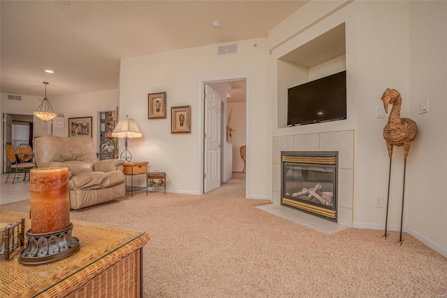 living room with a tile fireplace and light colored carpet