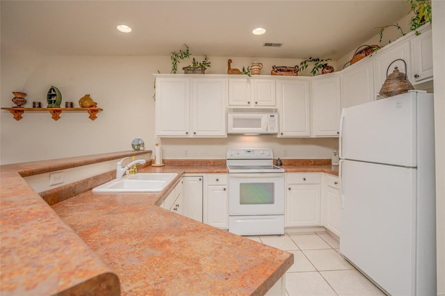 kitchen with white cabinets, light tile patterned flooring, white appliances, and sink