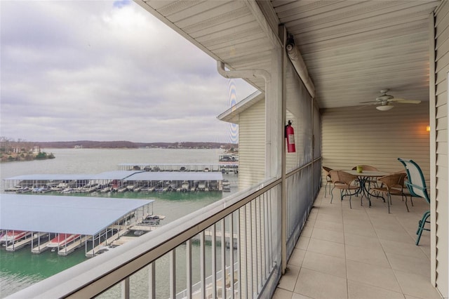 balcony with ceiling fan and a water view