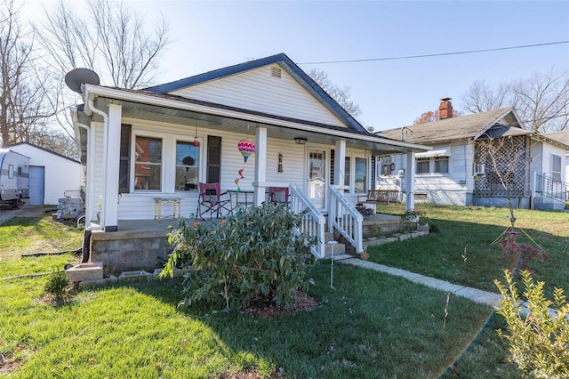 bungalow featuring covered porch and a front yard