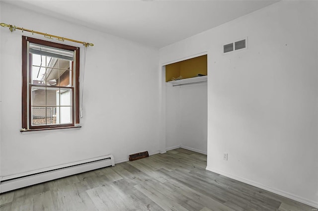 spare room featuring light hardwood / wood-style floors and baseboard heating