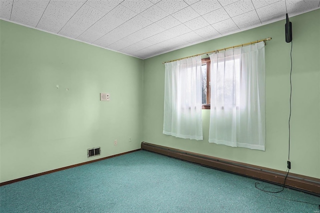 unfurnished room featuring carpet flooring and a baseboard heating unit