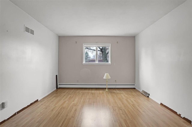 spare room featuring light hardwood / wood-style flooring and a baseboard heating unit