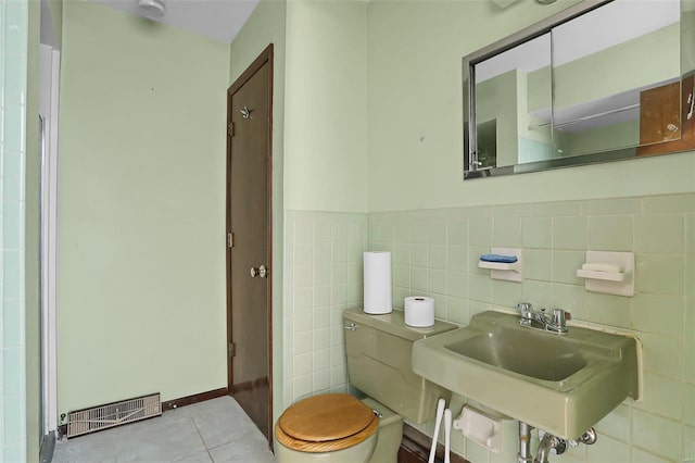 bathroom with tile patterned floors, sink, toilet, and tile walls