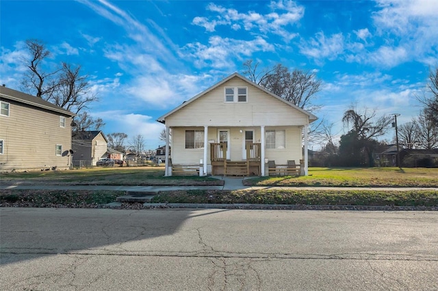 bungalow with covered porch and a front yard