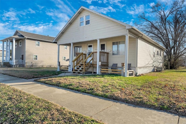 bungalow-style home featuring covered porch and a front yard