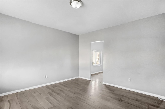 empty room with dark hardwood / wood-style flooring