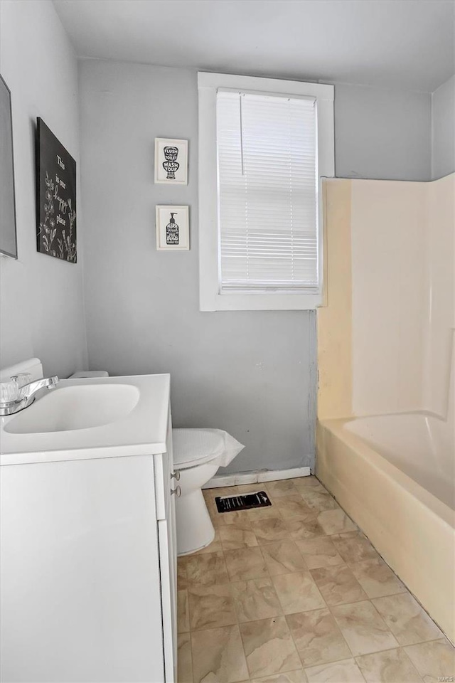 full bathroom featuring washtub / shower combination, vanity, and toilet