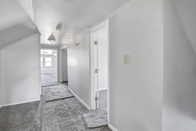 hallway with carpet flooring and vaulted ceiling