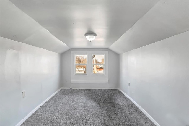 additional living space featuring carpet flooring and vaulted ceiling