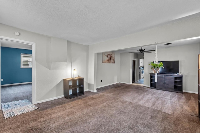 unfurnished living room featuring ceiling fan, dark carpet, and a textured ceiling