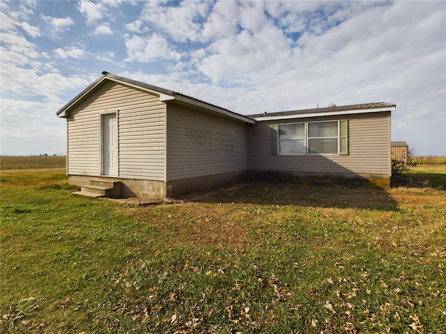 view of side of home with a yard