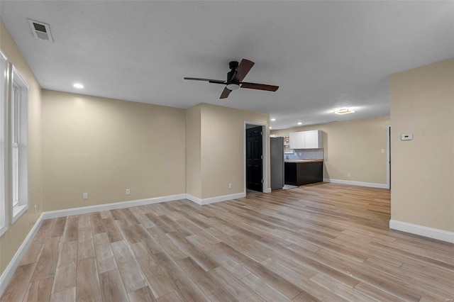 unfurnished living room featuring light hardwood / wood-style flooring and ceiling fan