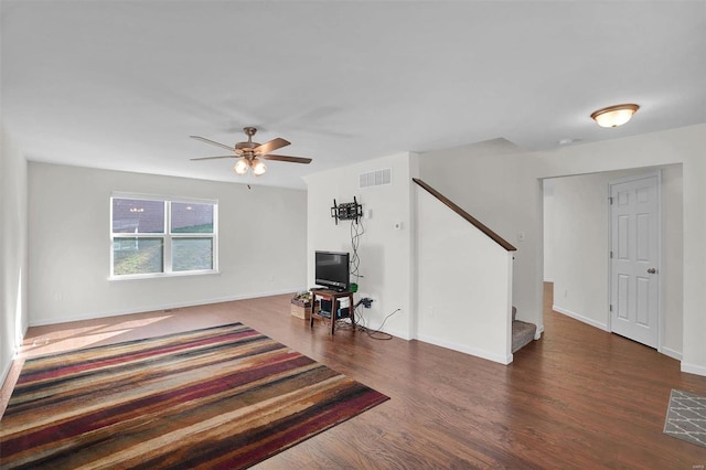 unfurnished living room featuring ceiling fan and dark wood-type flooring