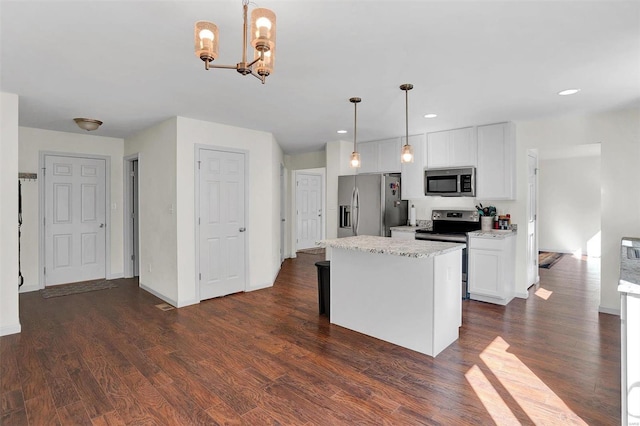 kitchen with decorative light fixtures, stainless steel appliances, white cabinetry, and dark hardwood / wood-style floors