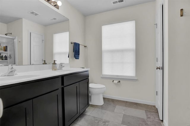 bathroom featuring a shower with door, vanity, a healthy amount of sunlight, and toilet