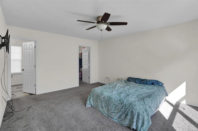 carpeted bedroom with a closet, a walk in closet, ensuite bathroom, and ceiling fan