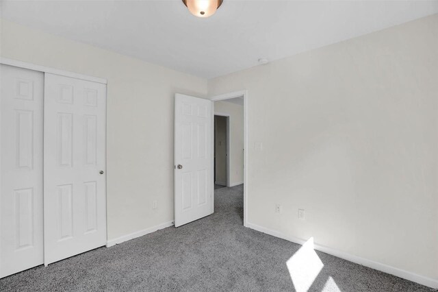 unfurnished bedroom featuring carpet and a closet