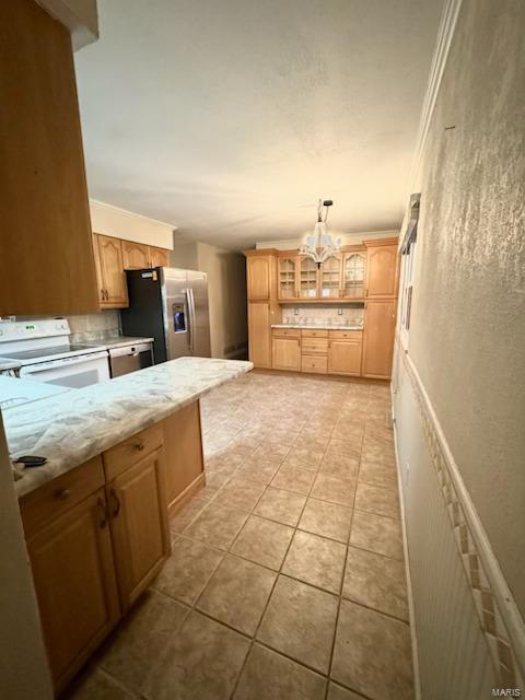 kitchen with hanging light fixtures, light stone countertops, light tile patterned flooring, white range oven, and stainless steel fridge with ice dispenser