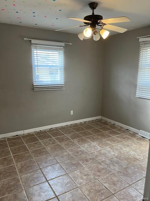 unfurnished room featuring ceiling fan and a healthy amount of sunlight