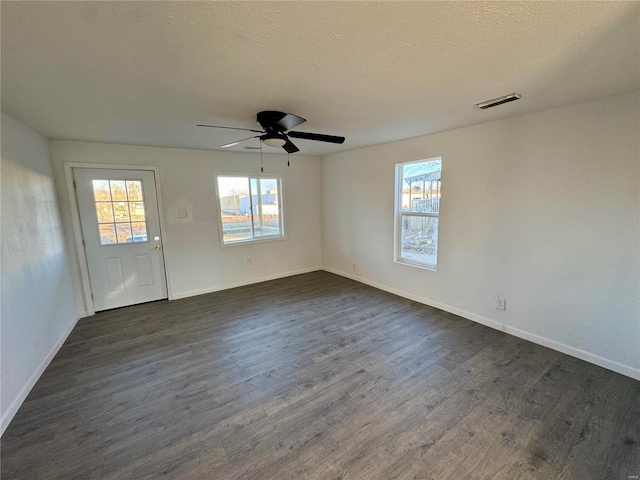 unfurnished room with ceiling fan, dark hardwood / wood-style floors, and a textured ceiling